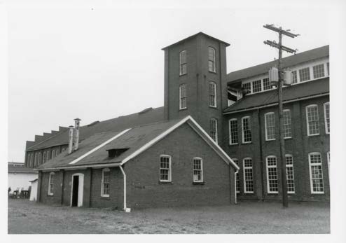 Annealing room. The gabled brick annealing room added by 1921, with the 1900 stair tower behind it and the sawtooth clerestory running left.